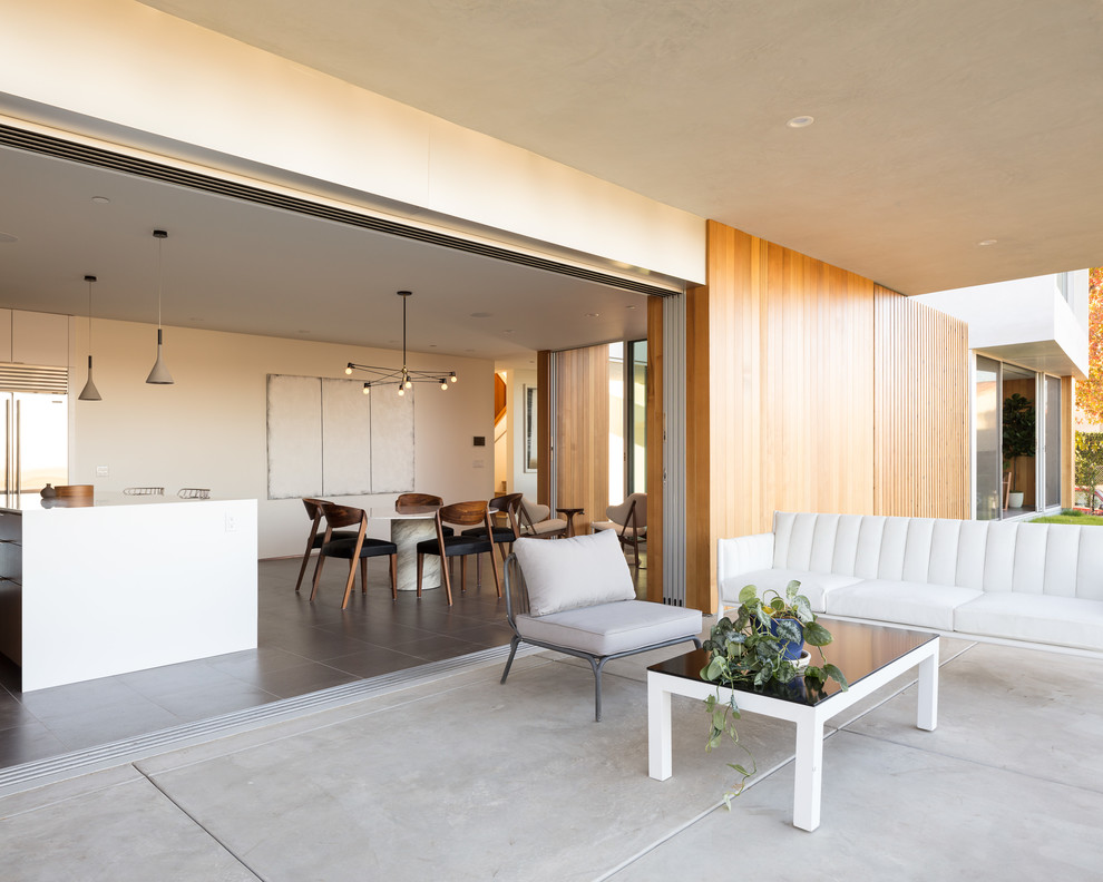 Пример оригинального дизайна: двор среднего размера на заднем дворе в стиле модернизм с покрытием из бетонных плит и навесом