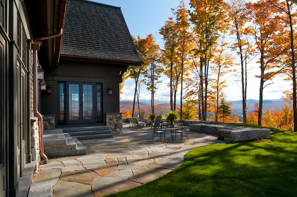 Foto di un ampio patio o portico tradizionale dietro casa con pavimentazioni in pietra naturale e nessuna copertura