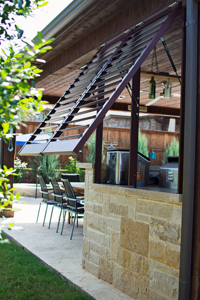 Aménagement d'une grande terrasse arrière classique avec une cuisine d'été, du béton estampé et une extension de toiture.