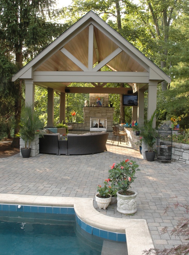 Immagine di un grande patio o portico tropicale dietro casa con un focolare, pavimentazioni in pietra naturale e un gazebo o capanno