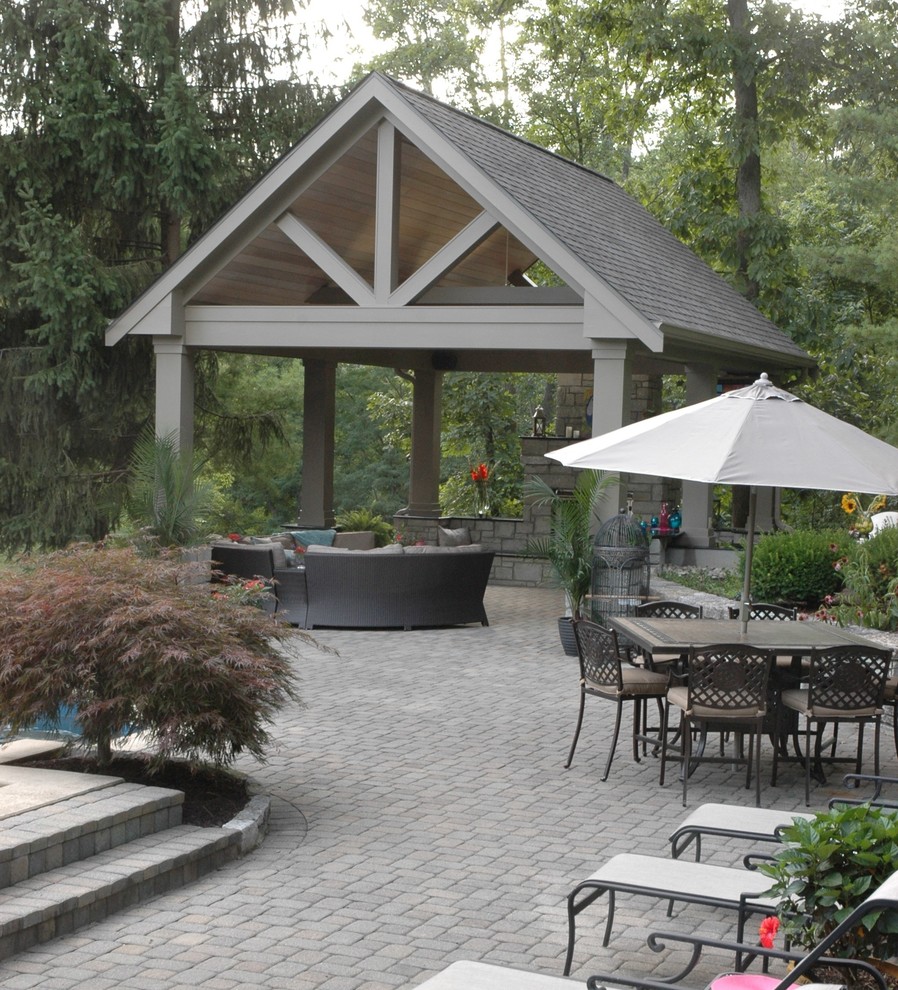 Large island style backyard stone patio photo in Cincinnati with a fire pit and a gazebo