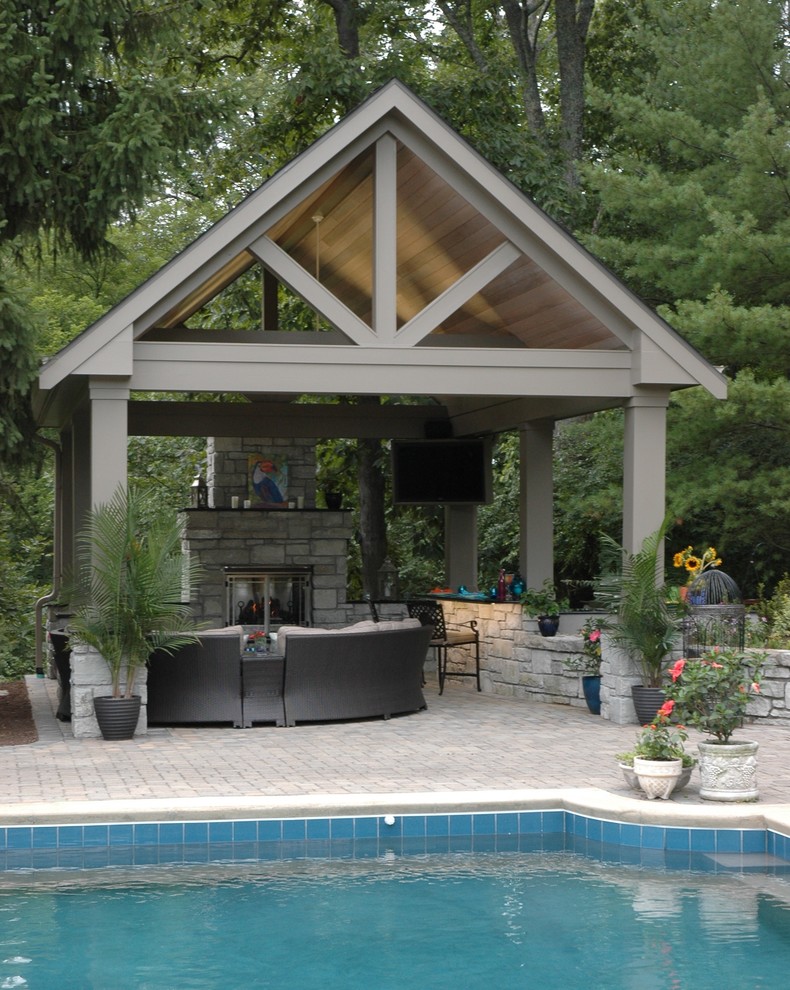 Foto di un grande patio o portico tropicale dietro casa con un focolare, pavimentazioni in pietra naturale e un gazebo o capanno