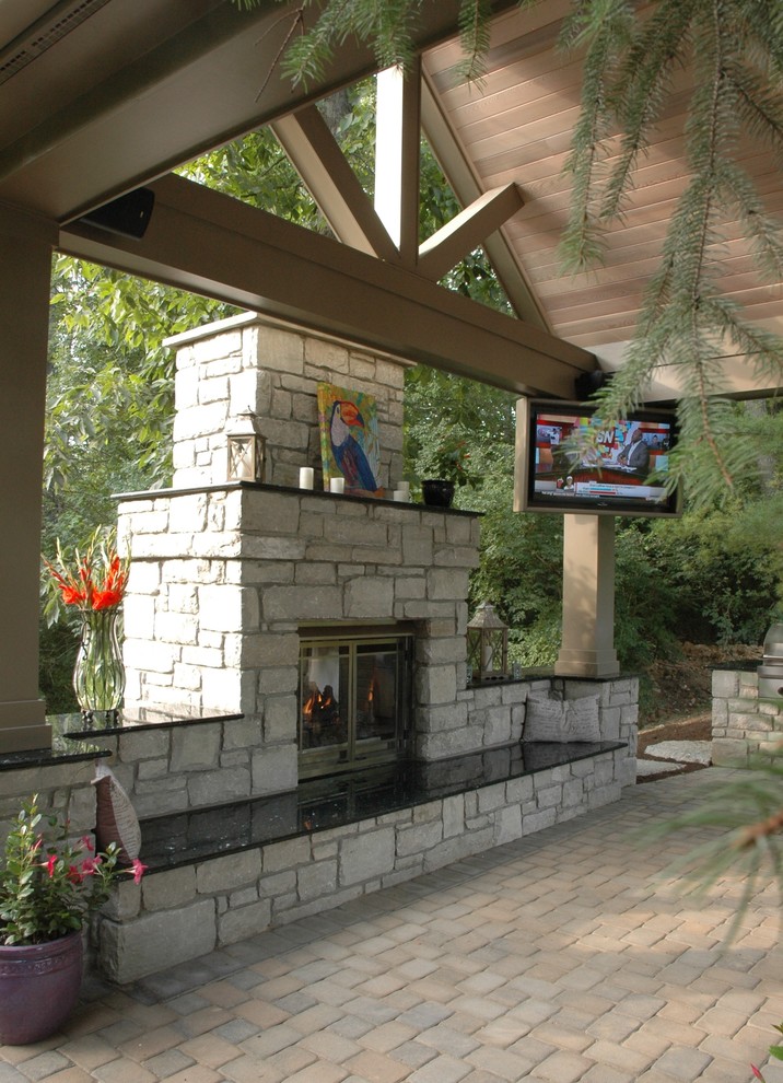 Modelo de patio exótico grande en patio trasero con brasero, adoquines de piedra natural y cenador