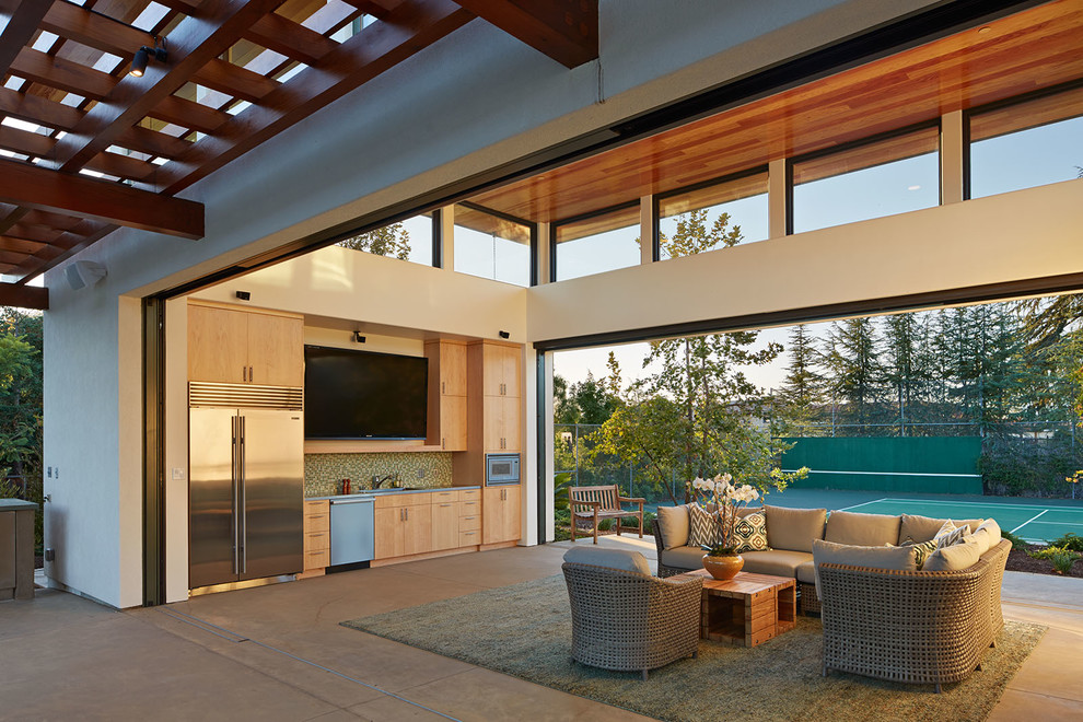 Aménagement d'une terrasse arrière contemporaine avec une dalle de béton et une cuisine d'été.