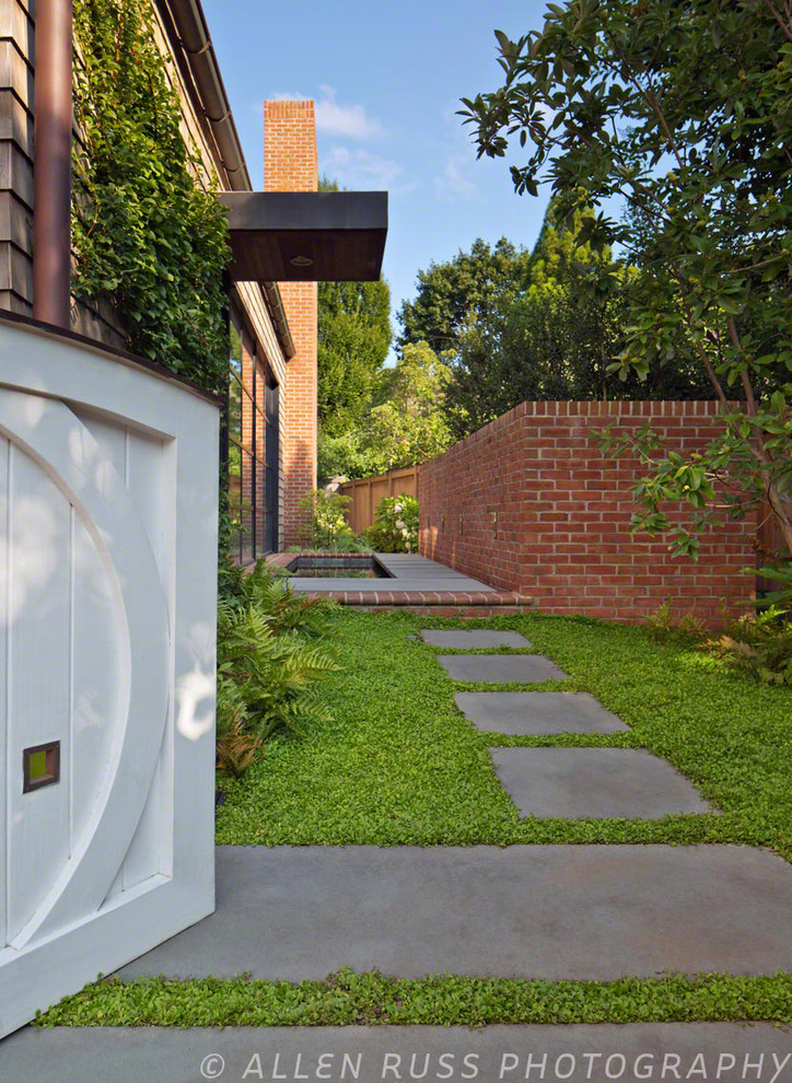 Esempio di un patio o portico minimalista con fontane, pavimentazioni in pietra naturale e un tetto a sbalzo