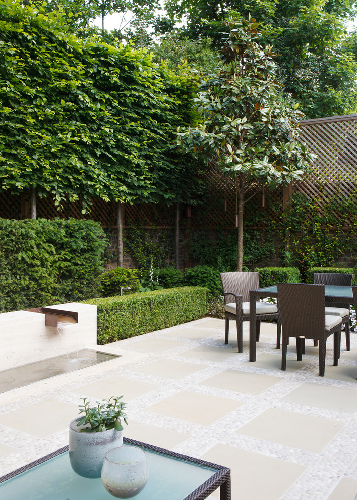 Esempio di un piccolo patio o portico minimal in cortile con fontane e pavimentazioni in pietra naturale