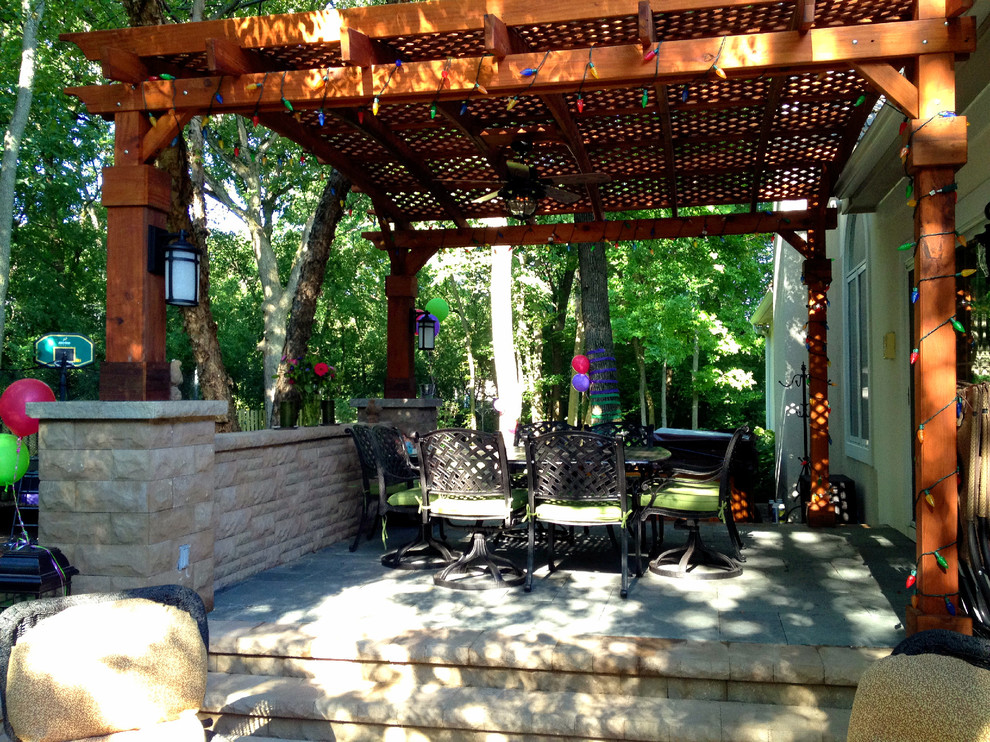 Imagen de patio actual grande en patio trasero con brasero, adoquines de ladrillo y pérgola