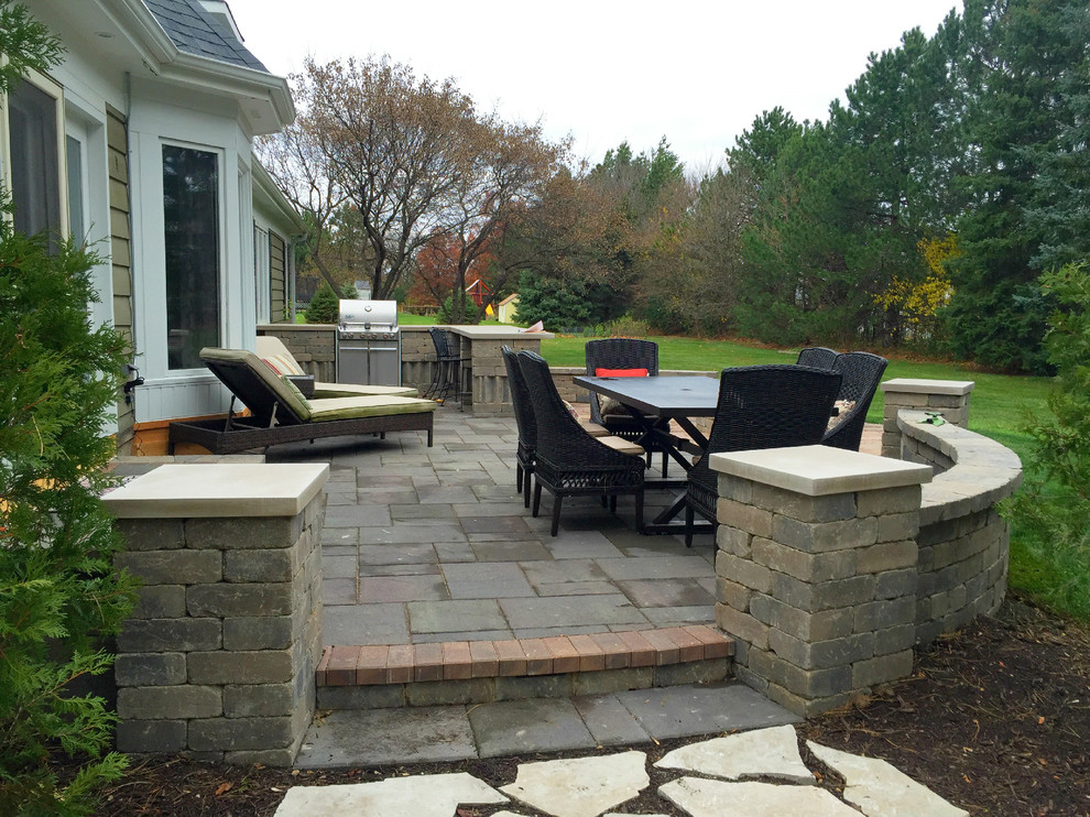 Design ideas for a large classic back patio in Chicago with an outdoor kitchen, brick paving and no cover.