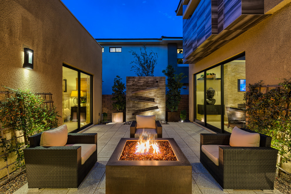 Diseño de patio contemporáneo sin cubierta en patio con brasero y losas de hormigón