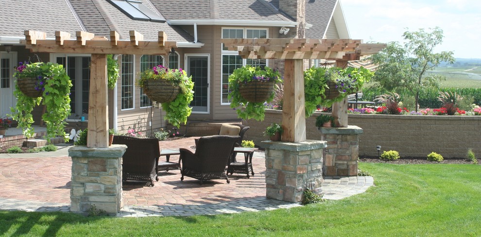 Esempio di un grande patio o portico rustico dietro casa con pavimentazioni in cemento e una pergola