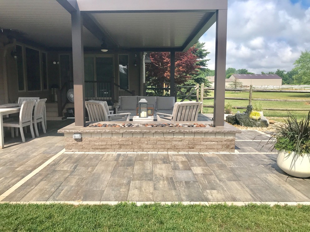 Example of a large classic backyard stamped concrete patio design in Detroit with a fire pit and a pergola