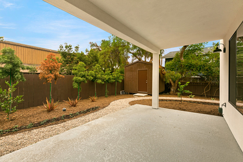 Foto di un patio o portico contemporaneo di medie dimensioni e dietro casa con lastre di cemento e un tetto a sbalzo