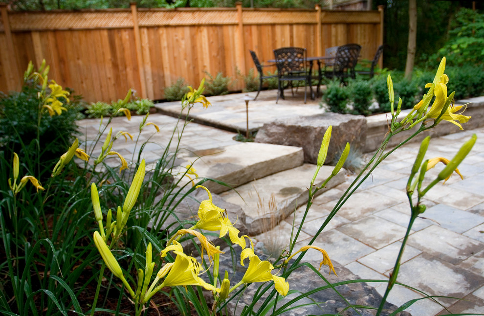 Mid-sized mountain style backyard concrete paver patio photo in Toronto with no cover