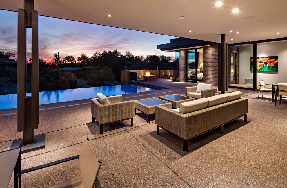 Inspiration for a back patio in Phoenix with a fire feature, concrete slabs and a roof extension.