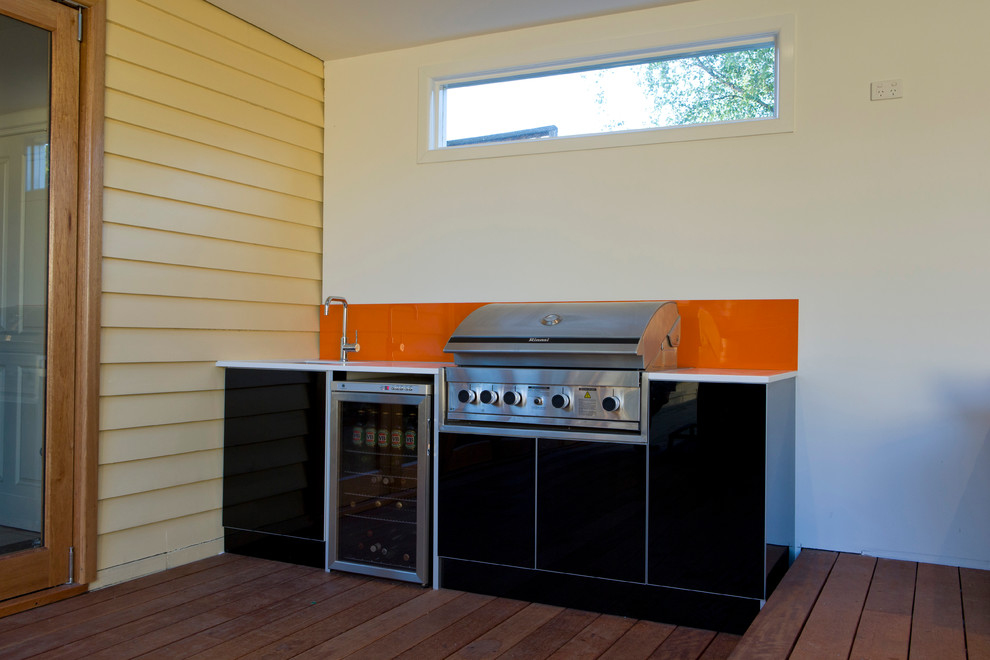 Idée de décoration pour une terrasse en bois arrière design avec une cuisine d'été et une extension de toiture.