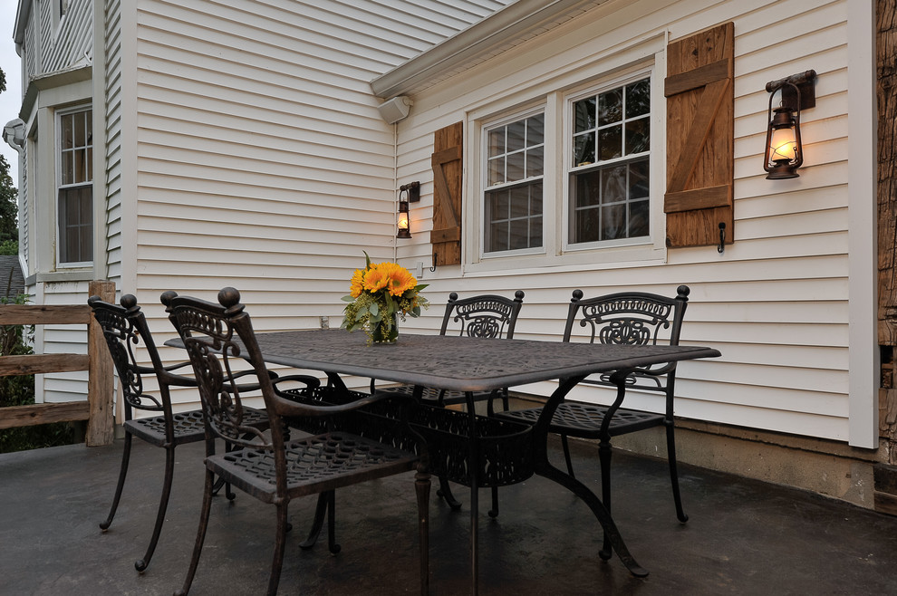Foto de patio campestre de tamaño medio sin cubierta en patio trasero con losas de hormigón y cocina exterior