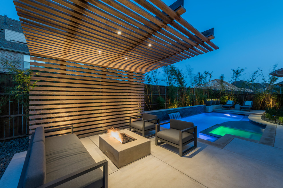 Kleine Moderne Pergola hinter dem Haus mit Feuerstelle und Betonplatten in Dallas