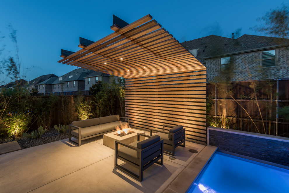 Kleine Moderne Pergola hinter dem Haus mit Feuerstelle und Betonplatten in Dallas