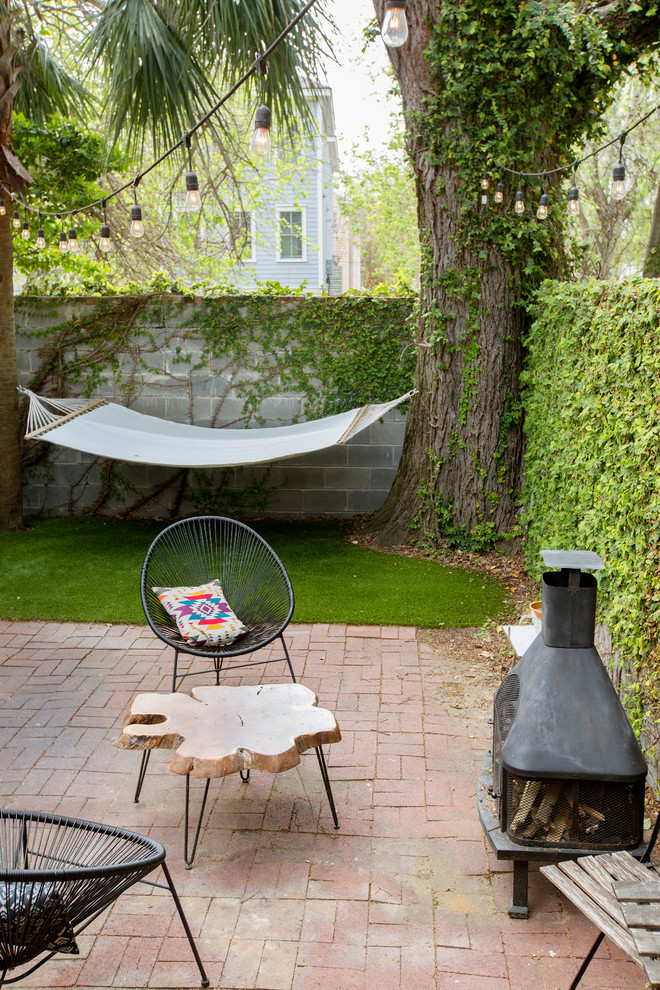 チャールストンにあるコンテンポラリースタイルのおしゃれな裏庭のテラス (レンガ敷き、日よけなし、屋外暖炉) の写真