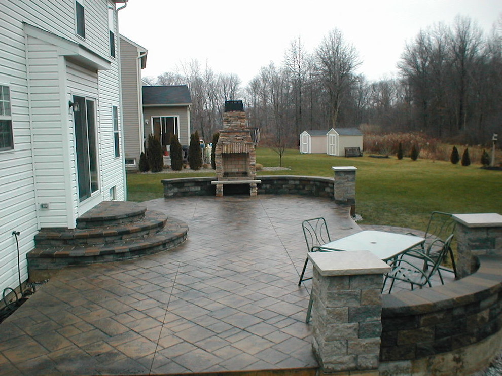 Esempio di un patio o portico tradizionale di medie dimensioni e dietro casa con un focolare e pavimentazioni in mattoni