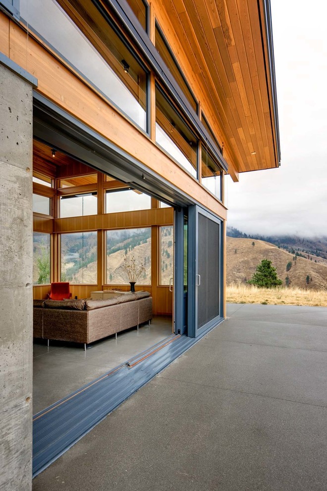 Überdachter Moderner Patio hinter dem Haus mit Betonplatten in Seattle