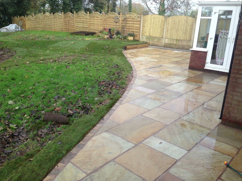Example of a large classic backyard stone patio design in Oxfordshire