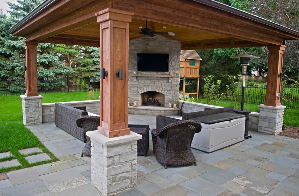 Diseño de patio grande en patio trasero con cocina exterior, adoquines de piedra natural y toldo