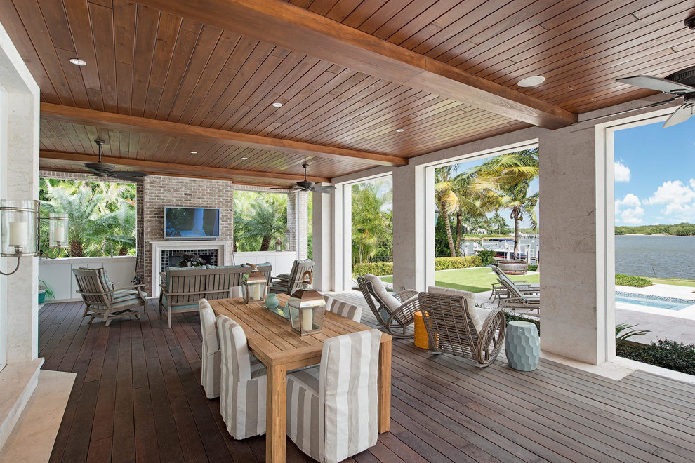 Cette image montre une terrasse en bois arrière marine de taille moyenne avec un foyer extérieur et une extension de toiture.