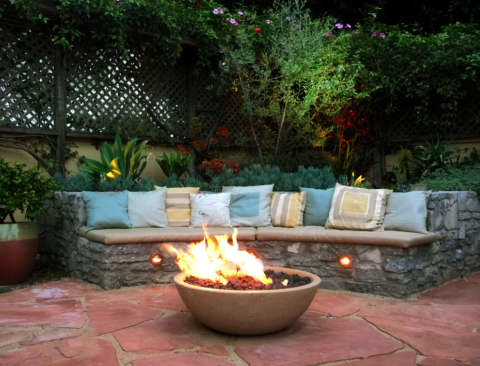 ロサンゼルスにある高級な広い地中海スタイルのおしゃれな裏庭のテラス (ファイヤーピット、天然石敷き、日よけなし) の写真