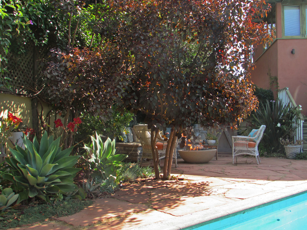 На фото: большой двор на заднем дворе в средиземноморском стиле с покрытием из каменной брусчатки и местом для костра без защиты от солнца с