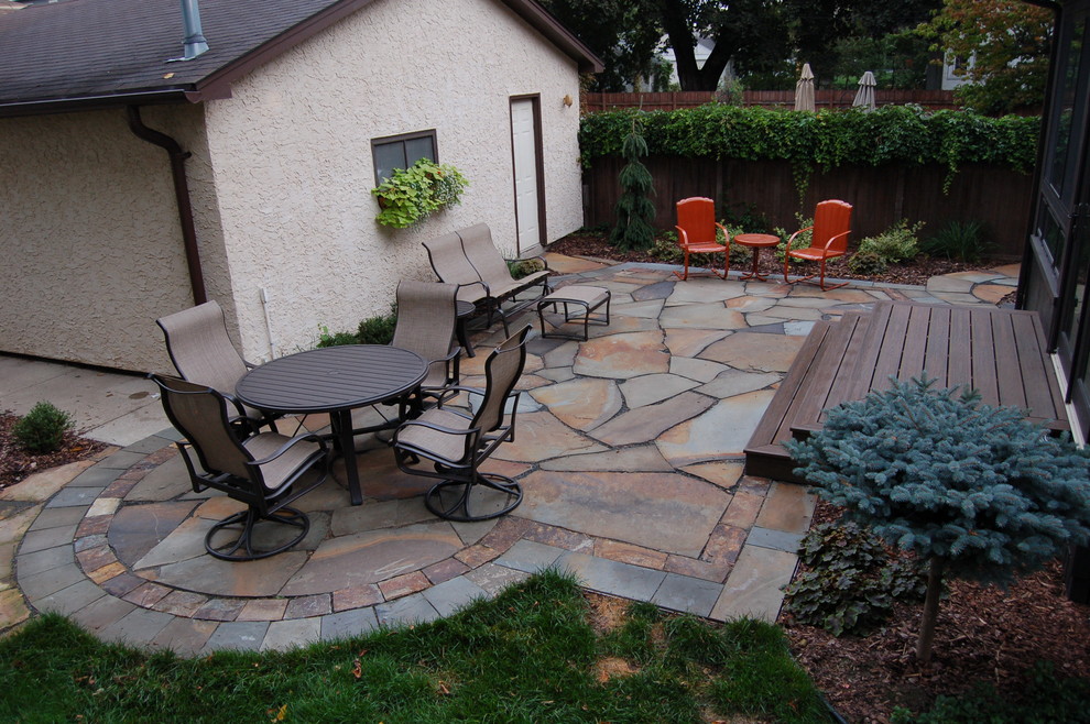 Immagine di un piccolo patio o portico classico dietro casa con pavimentazioni in pietra naturale
