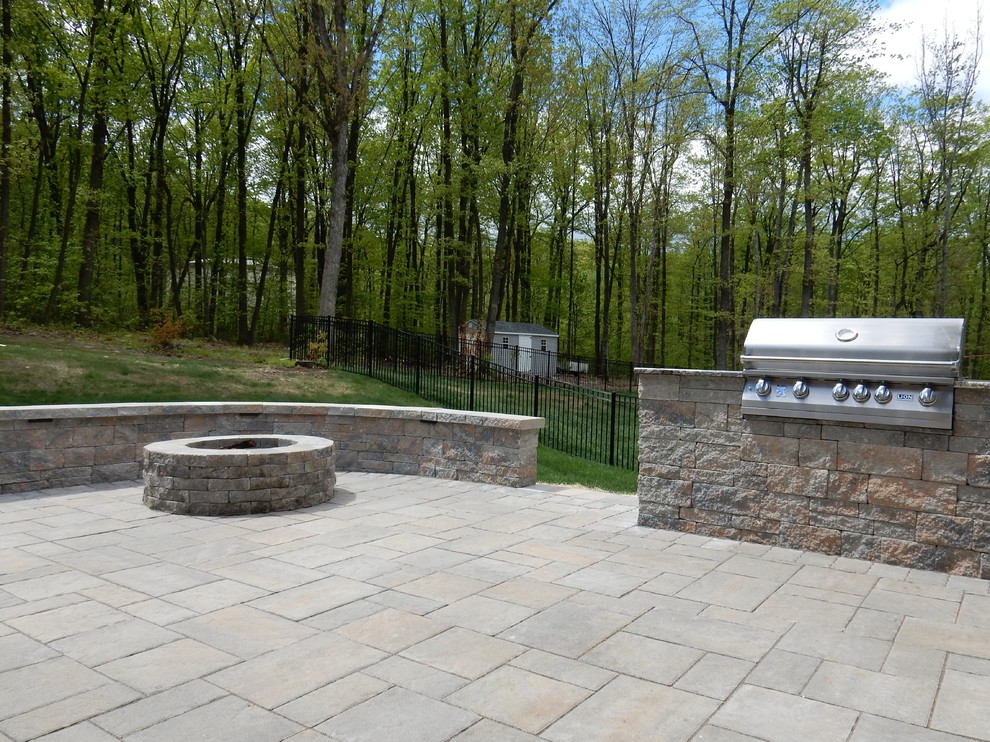 Large elegant backyard stone patio photo in Philadelphia with a fire pit and no cover