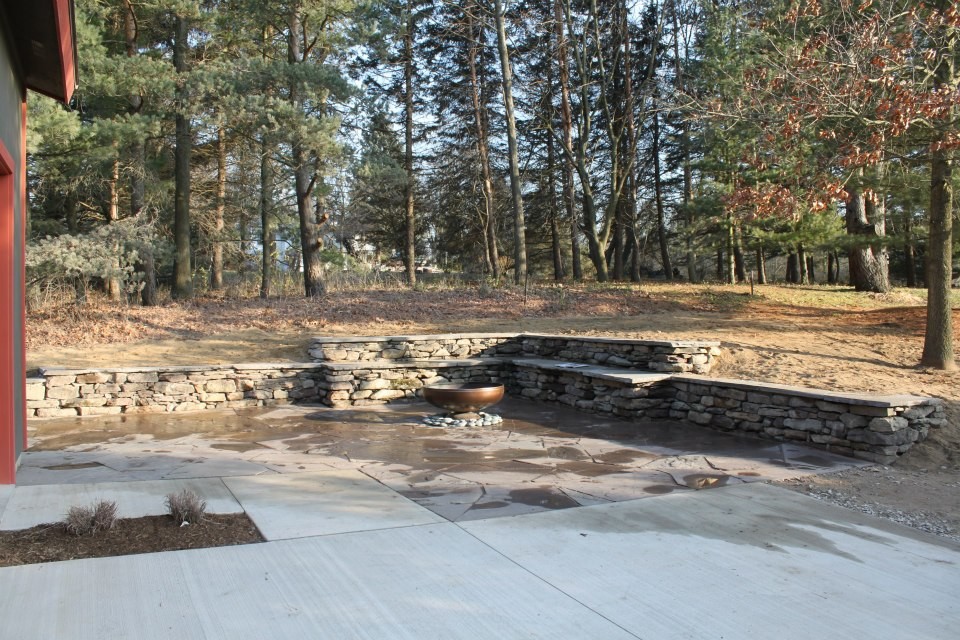 Imagen de patio rural de tamaño medio sin cubierta en patio trasero con brasero y adoquines de piedra natural