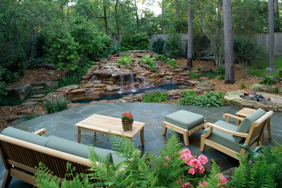 Mid-sized island style backyard stone patio photo in Houston