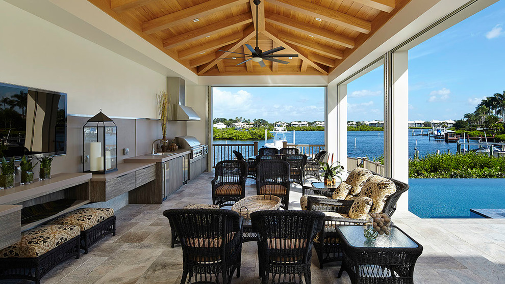 Réalisation d'une grande terrasse marine avec une cuisine d'été, du carrelage et une extension de toiture.