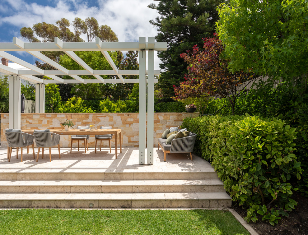 Photo of a large mediterranean back patio in Perth with natural stone paving and a pergola.