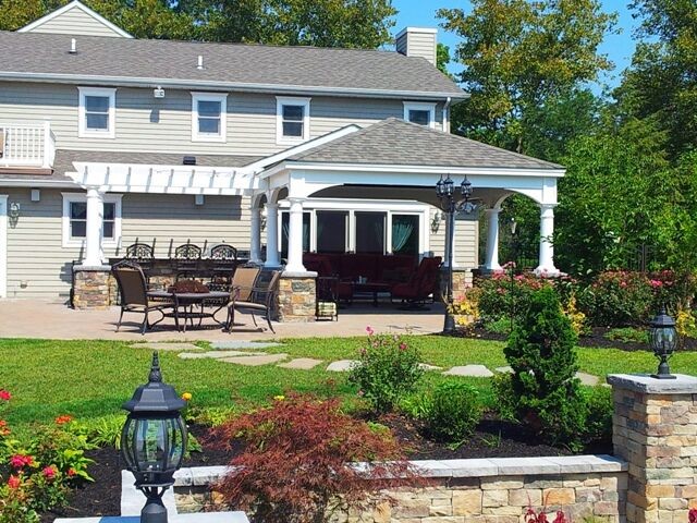 Design ideas for a medium sized traditional back patio in Philadelphia with an outdoor kitchen, natural stone paving and a gazebo.