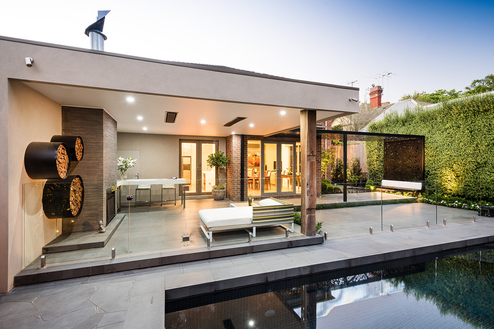 Patio - mid-sized modern backyard concrete paver patio idea in Melbourne with a fire pit and a roof extension