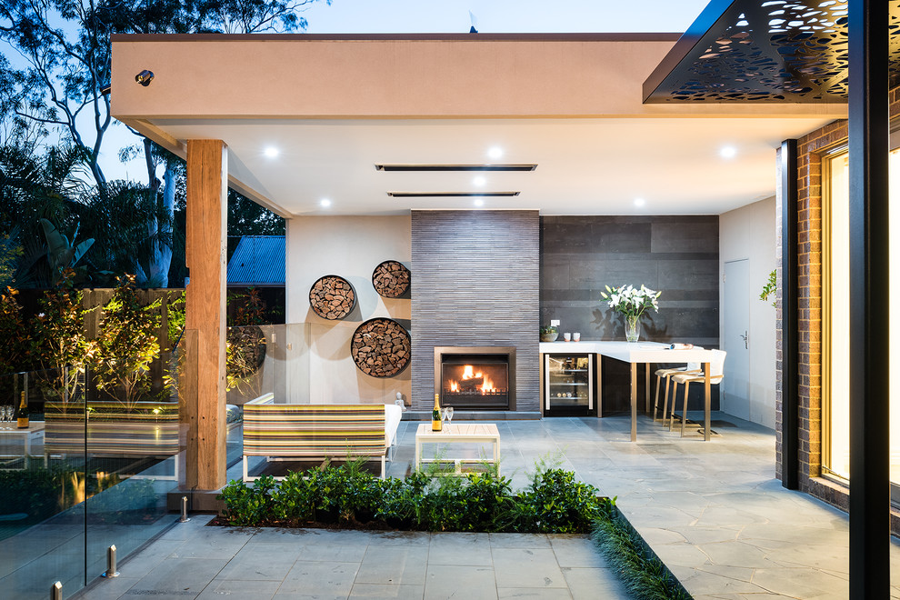 Idee per un patio o portico minimal di medie dimensioni e dietro casa con cemento stampato e un tetto a sbalzo