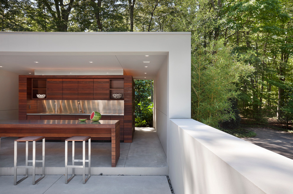 This is an example of a large modern back patio in New York with a gazebo, an outdoor kitchen and concrete slabs.