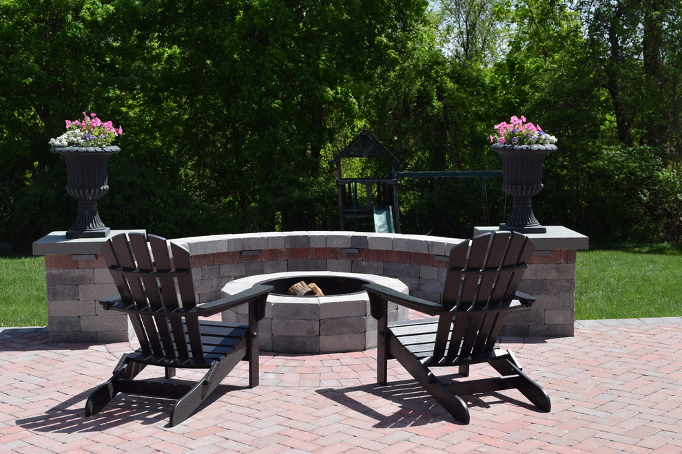 This is an example of a medium sized classic back patio in Providence with a fire feature, concrete paving and no cover.