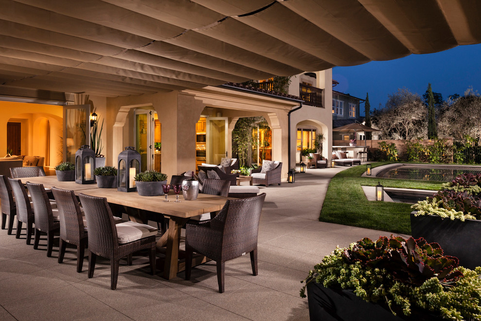Example of a tuscan patio design in Los Angeles with a roof extension