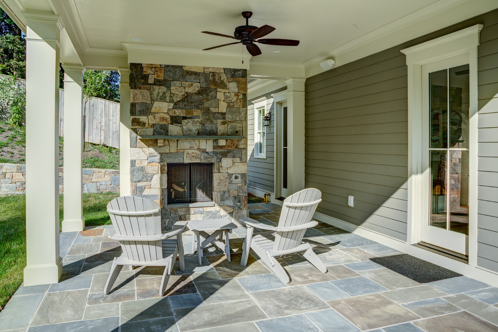 Photo of a medium sized traditional back patio in DC Metro with a fireplace, natural stone paving and a roof extension.