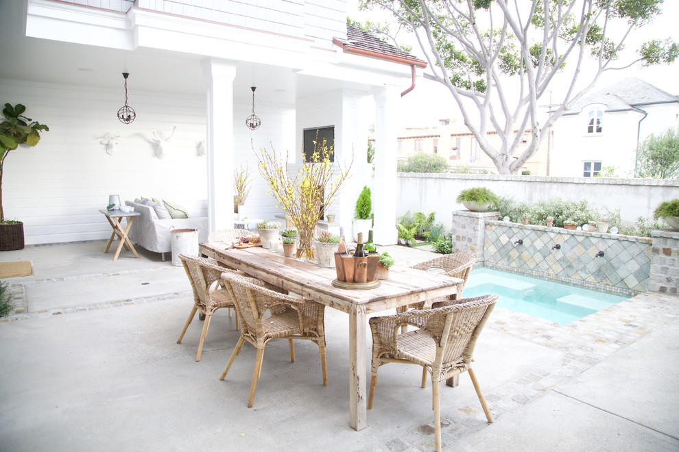 Inspiration for a country back patio in Orange County with a water feature and concrete slabs.
