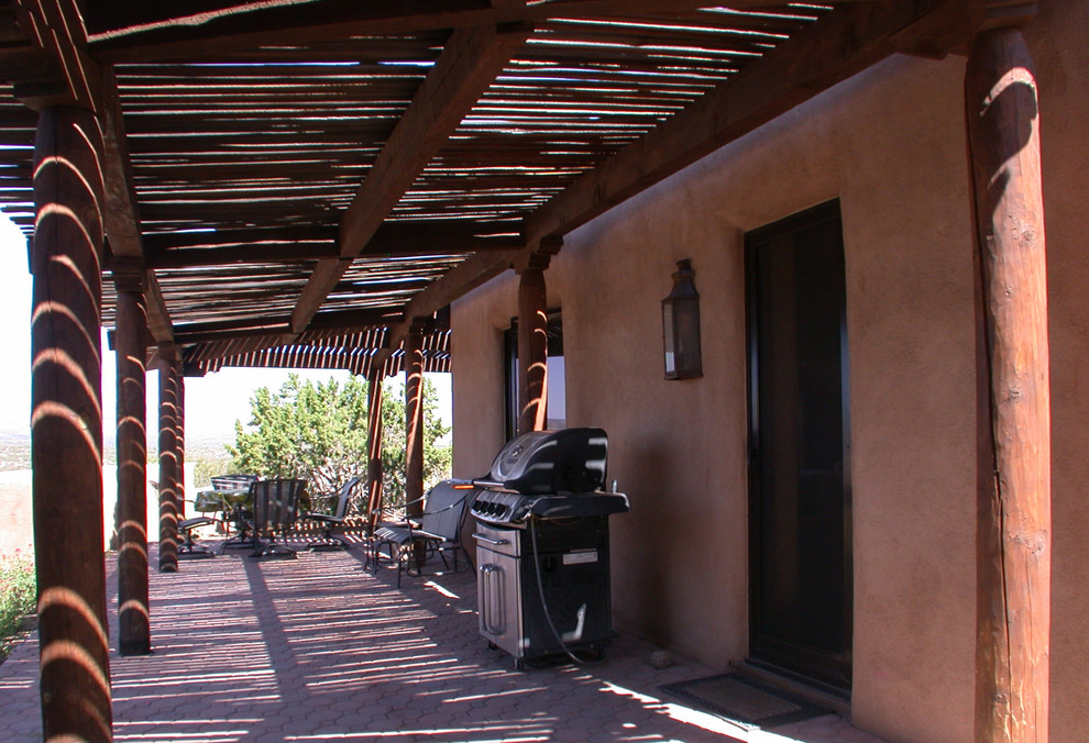 Patio - small southwestern side yard concrete paver patio idea in Albuquerque with a pergola
