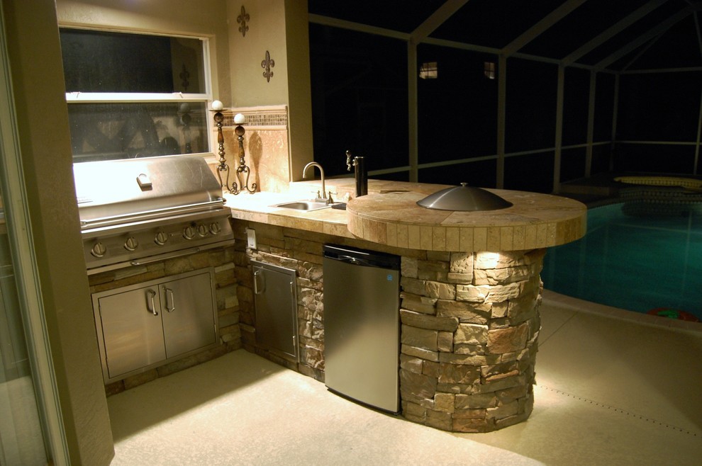 Patio kitchen - mid-sized rustic backyard concrete patio kitchen idea in Tampa with a roof extension
