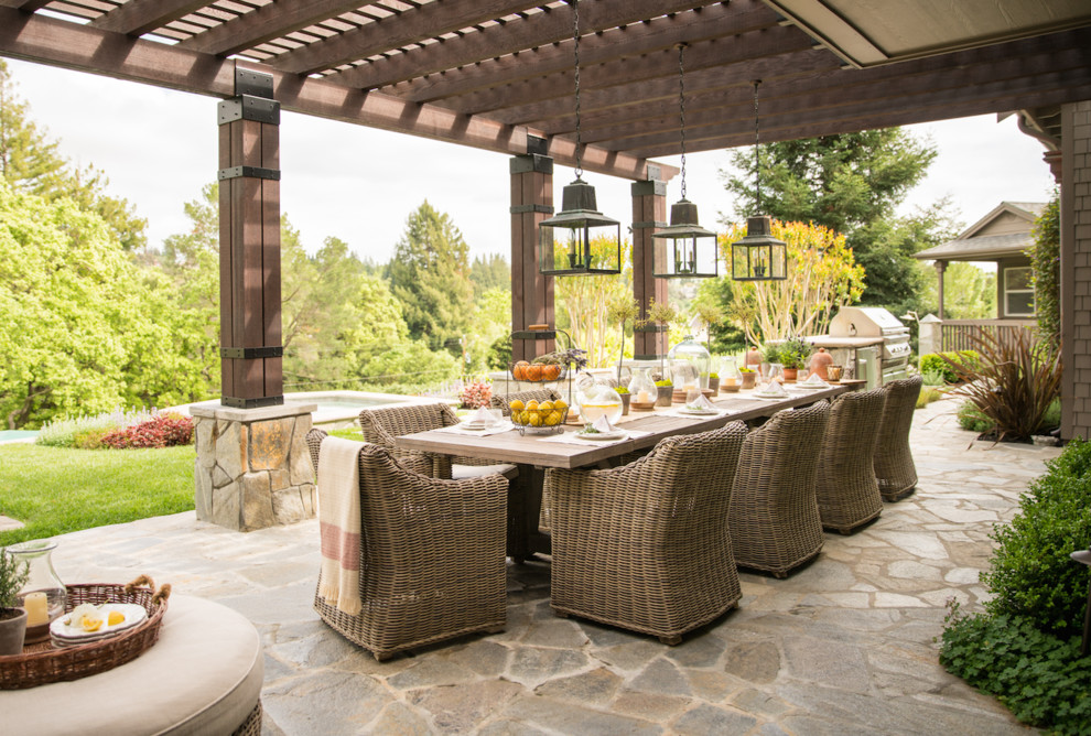 Idées déco pour une terrasse arrière classique de taille moyenne avec une cuisine d'été, des pavés en pierre naturelle et une pergola.