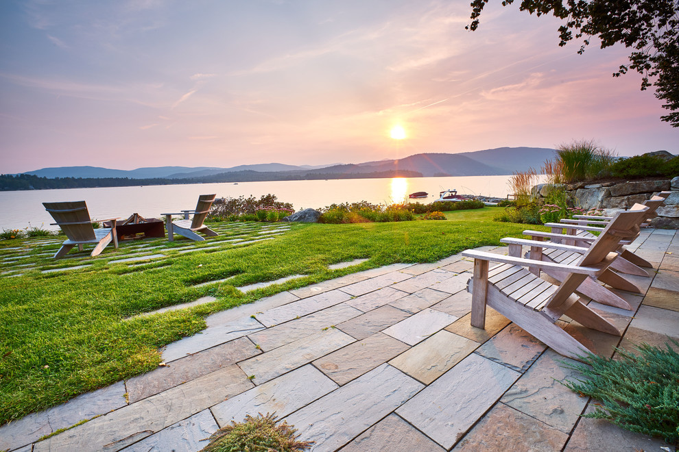 Inspiration pour une terrasse arrière marine avec un foyer extérieur, des pavés en pierre naturelle et aucune couverture.