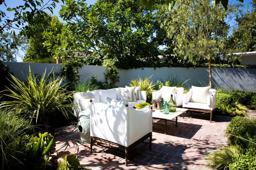 Foto de patio tropical de tamaño medio sin cubierta en patio trasero con adoquines de ladrillo