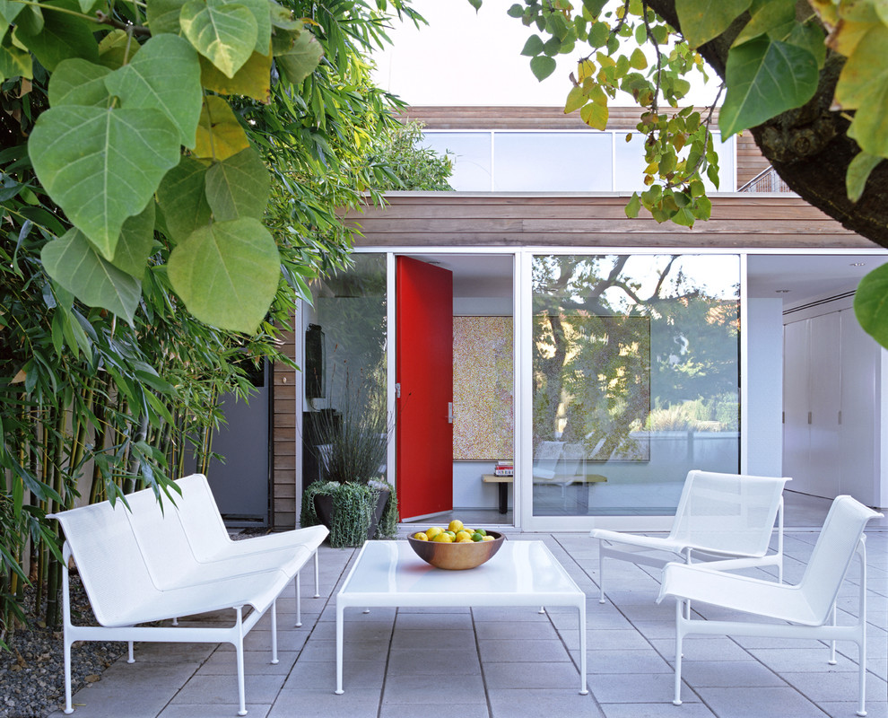 Idée de décoration pour une terrasse minimaliste de taille moyenne avec une cour, des pavés en pierre naturelle et aucune couverture.